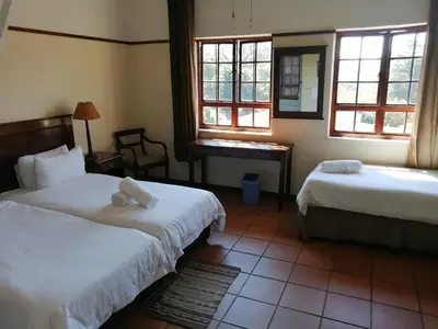a hotel room with two beds and a mirror at The Woodsman Bed and Breakfast in Sabie