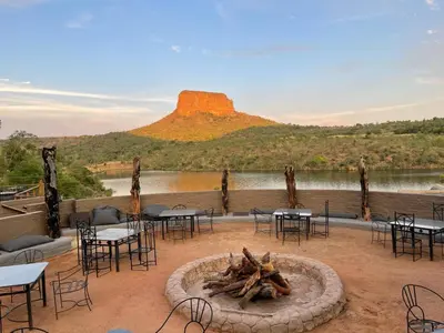 a group of tables and chairs around a fire pit at Entabeni Mountain Lodges in Golders Green