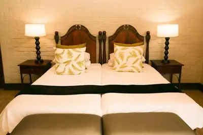 a bedroom with a bed with two tables and two lamps at Entabeni Mountain Lodges in Golders Green
