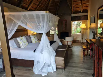 a bedroom with a bed with a mosquito net at Entabeni Mountain Lodges in Golders Green