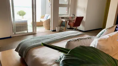 a living room with a bed and a table and a desk at Mister C in Hartbeespoort