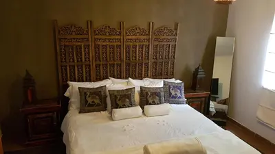 a bedroom with a large white bed with pillows at Wooden Creek Estate in Kempton Park