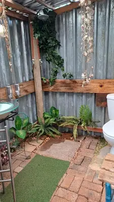 a garden with a toilet and a fence at Wooden Creek Estate in Kempton Park