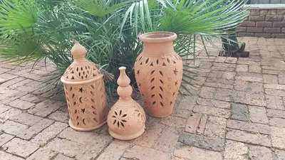 four vases sitting next to each other on a sidewalk at Wooden Creek Estate in Kempton Park