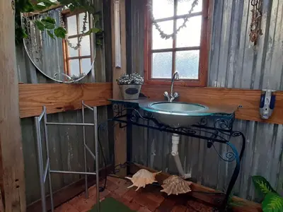 a bathroom with a sink and a mirror at Wooden Creek Estate in Kempton Park