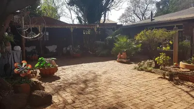 a patio with a bunch of potted plants on it at Wooden Creek Estate in Kempton Park