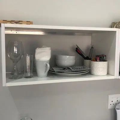 a white shelf with dishes and a wine glass at The Red Chimney in Pretoria