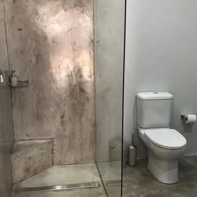 a bathroom with a toilet and a glass shower at The Red Chimney in Pretoria