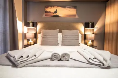 a bedroom with a white bed with towels on it at Meadowbrook Guesthouse in Pretoria