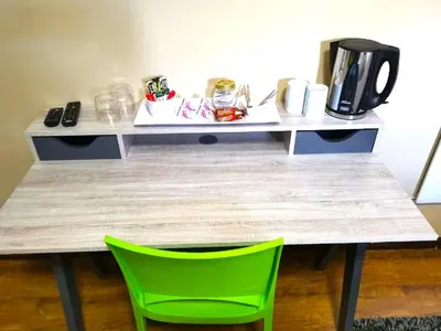 a table with two green chairs in a room at Meadowbrook Guesthouse in Pretoria
