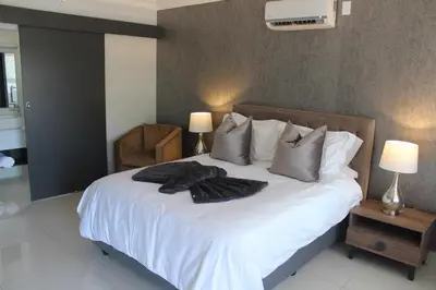 a bedroom with a bed with white sheets and pillows at Prisatt Boutique Hotel in Onverwacht