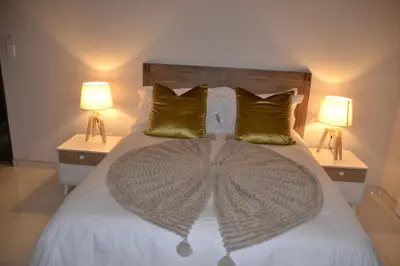 a bedroom with a large bed with two lamps at Prisatt Boutique Hotel in Onverwacht