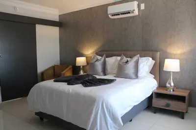 a bedroom with a bed with white sheets and pillows at Prisatt Boutique Hotel in Onverwacht