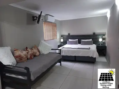 a bedroom with a bed and a couch in it at SnL 12 Dwergarend in Malelane