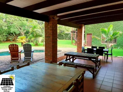 a patio with a table and chairs and a pool at SnL 12 Dwergarend in Malelane