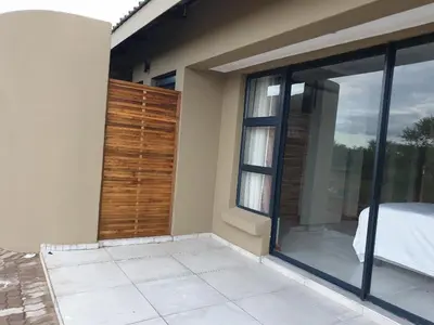 a bedroom with sliding glass doors and a bed at 42@ Ditholo Game Lodge in Thabazimbi