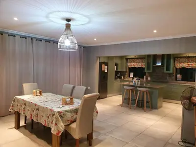 a dining room with a table and a kitchen at 42@ Ditholo Game Lodge in Thabazimbi