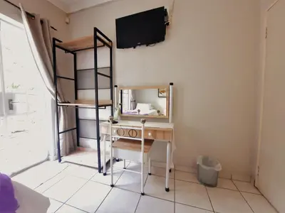 a room with a desk and a mirror on the wall at Highlands Creek Self Catering Accommodation in Nelspruit
