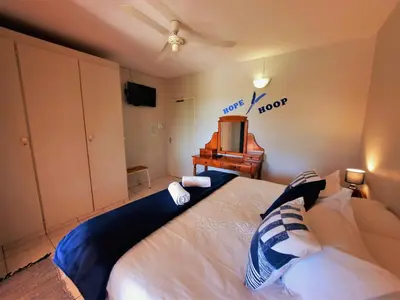 a bedroom with a large bed and a television at Highlands Creek Self Catering Accommodation in Nelspruit