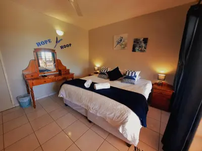 a bedroom with a bed with a mirror and a piano at Highlands Creek Self Catering Accommodation in Nelspruit