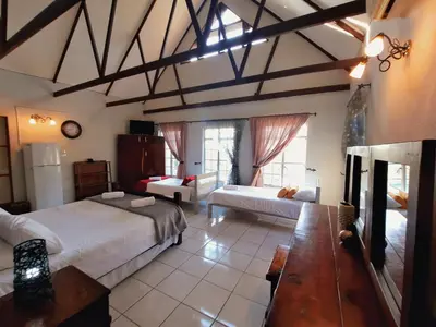 a large room with two beds and a table at Highlands Creek Self Catering Accommodation in Nelspruit