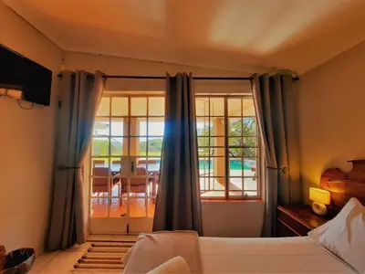 a bedroom with a bed and a view of a room at Highlands Creek Self Catering Accommodation in Nelspruit