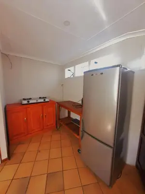 a kitchen with a stainless steel refrigerator and a wooden table at Highlands Creek Self Catering Accommodation in Nelspruit