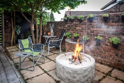 a fire pit in a yard with chairs and a table at Hello Sunshine Self Catering Studio Apartments in Nelspruit