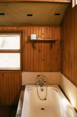 a bath tub in a room with a window at Kelora Bush Camp in Hoedspruit