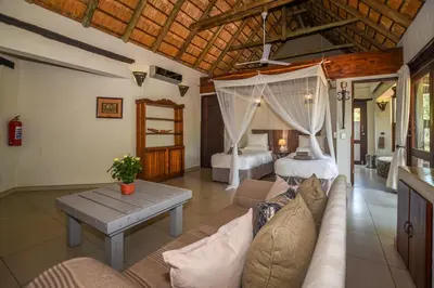 a living room with a couch and a bedroom at Leopard's Lair Bush Lodge in Hoedspruit