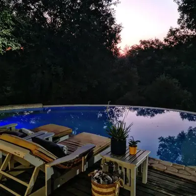 a deck with chairs and a swimming pool at Leopard's Lair Bush Lodge in Hoedspruit