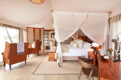 a bedroom with a canopy bed and a desk at Thabamati Luxury Tented Camp in Timbavati Game Reserve