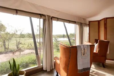 a room with two chairs and a large window at Thabamati Luxury Tented Camp in Timbavati Game Reserve