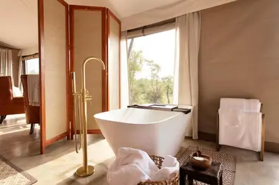 a bathroom with a bath tub and a window at Thabamati Luxury Tented Camp in Timbavati Game Reserve
