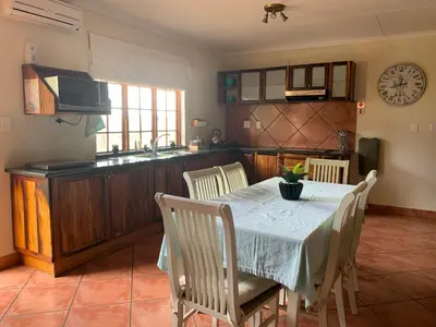 a kitchen and dining room with a table and chairs at Modjadji Estate Lodge & Spa in Grietjie Nature Reserve
