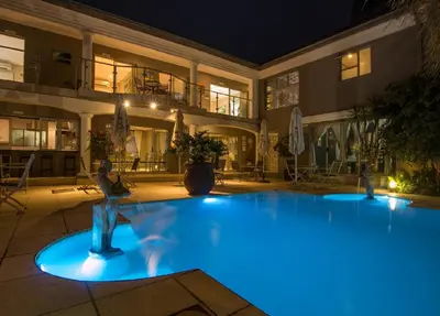 a large swimming pool at night with blue lights at Club Cocomo in Hartbeespoort