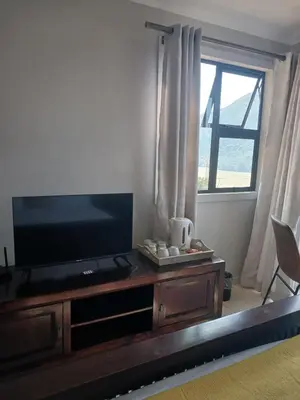 a living room with a television and a window at Cozy Kosmos in Hartbeespoort