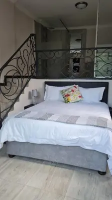 a bedroom with a large bed with a metal headboard at Cozy Kosmos in Hartbeespoort