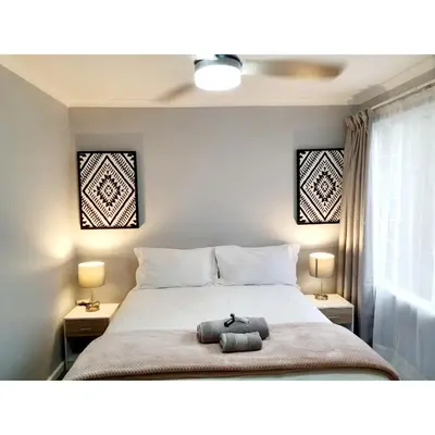 a bedroom with a bed with a stuffed animal on it at Waterfall Bed & Breakfast in Midrand