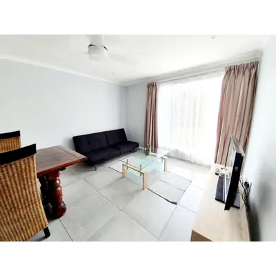 a living room with a couch and a table at Waterfall Bed & Breakfast in Midrand