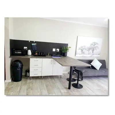 a wooden table in a room with a desk at Waterfall Bed & Breakfast in Midrand
