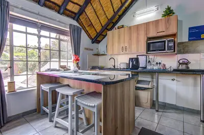 a kitchen with a large counter with stools in it at Lavender Villa No loadshedding in Kempton Park