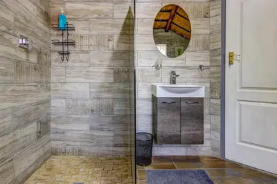 a bathroom with a shower with a sink and a mirror at Lavender Villa No loadshedding in Kempton Park
