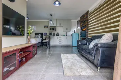 a living room with a couch and a kitchen at Lavender Villa No loadshedding in Kempton Park