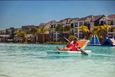 a young child is sitting on a kayak in the water at The Blyde Crystal lagoon Pretoria in Pretoria