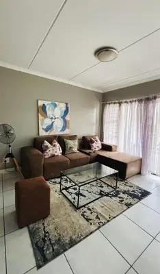 a living room with a couch and a glass table at The Blyde Crystal lagoon Pretoria in Pretoria