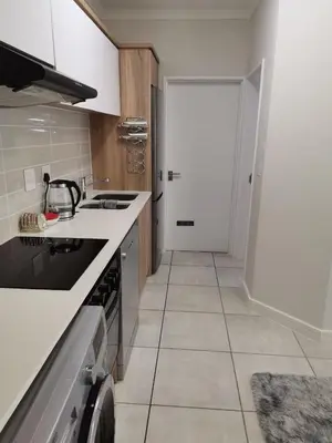 a kitchen with white counters and a white door at The Blyde Crystal lagoon Pretoria in Pretoria