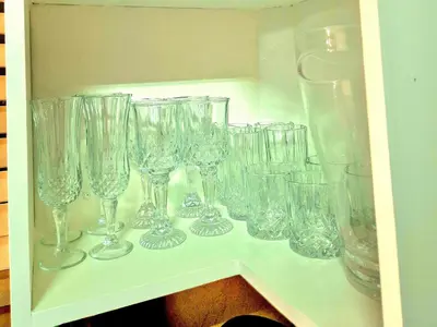 a shelf filled with glasses on a shelf at URlyfstyle Cottage 10km from OR Tambo Int Airport in Kempton Park