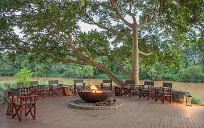 a fire pit with tables and chairs on a patio at Abelana River Lodge in Phalaborwa