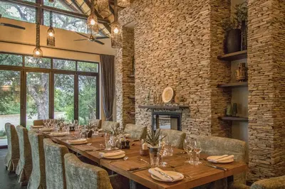 a dining room with a long table and chairs at Abelana River Lodge in Phalaborwa